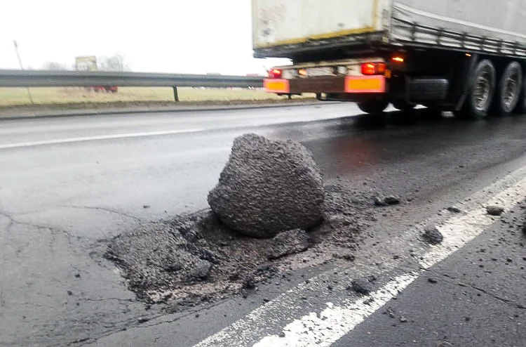 Uwaga kierowcy! Ogromna wyrwa i ''sterczący'' asfalt na drodze. Lepiej zachować ostrożność - Zdjęcie główne