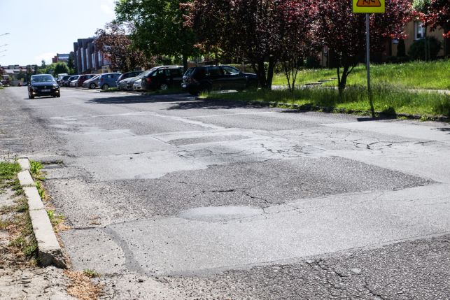 Wyboje, wystające studzienki i asfalt sprzed blisko 30 lat... tak wygląda główna droga na dużym osiedlu w Bełchatowie - Zdjęcie główne