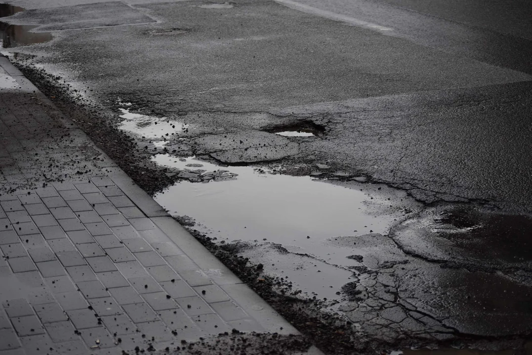 Fatalny stan drogi przy przystanku w centrum Łodzi. Z dziur robią się jeziora, a krawężniki nie istnieją [zdjęcia]