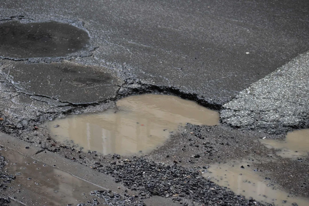 Fatalny stan drogi przy przystanku w centrum Łodzi. Z dziur robią się jeziora, a krawężniki nie istnieją [zdjęcia]