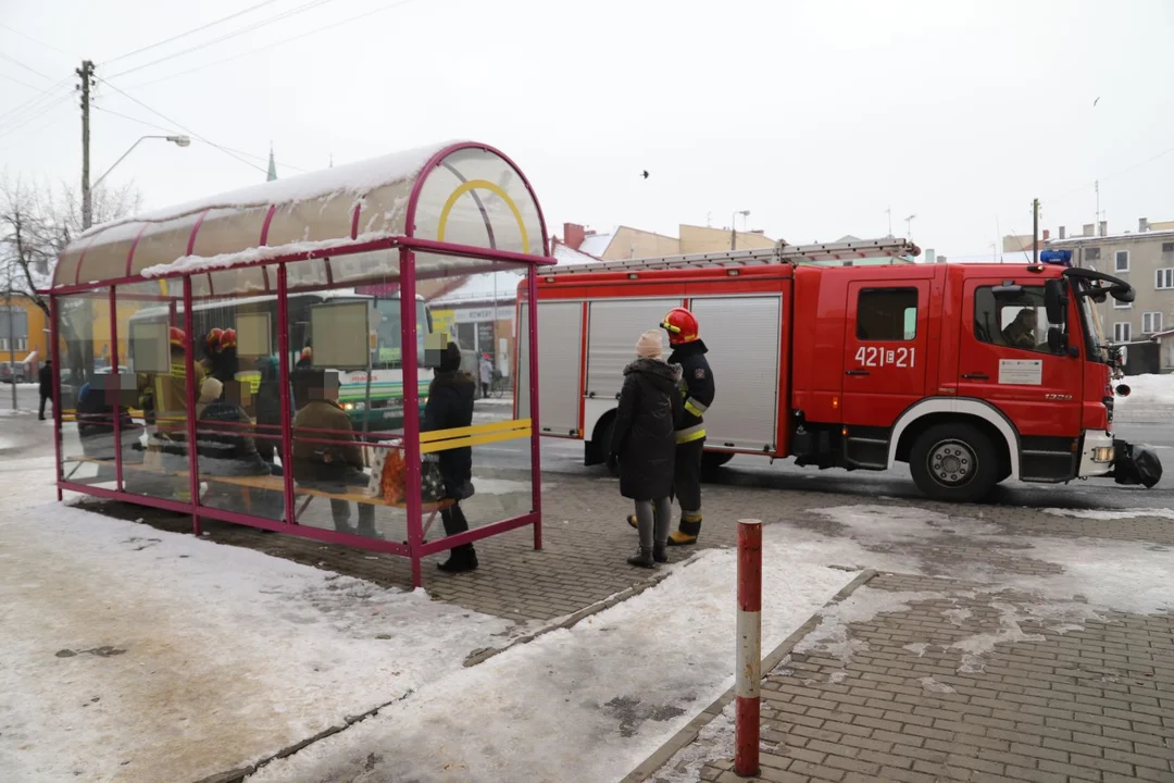 Na przystanku autobusowym w centrum miasta zasłabł starszy mężczyzna, pomagają mu strażacy