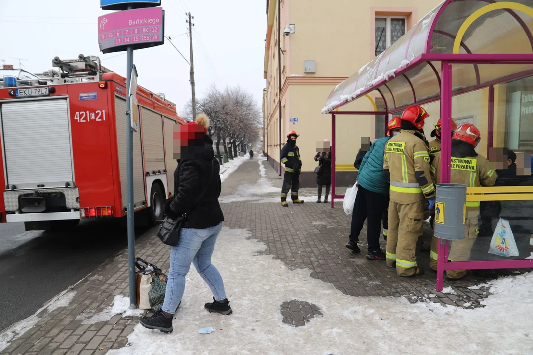 Na przystanku autobusowym w centrum miasta zasłabł starszy mężczyzna, pomagają mu strażacy