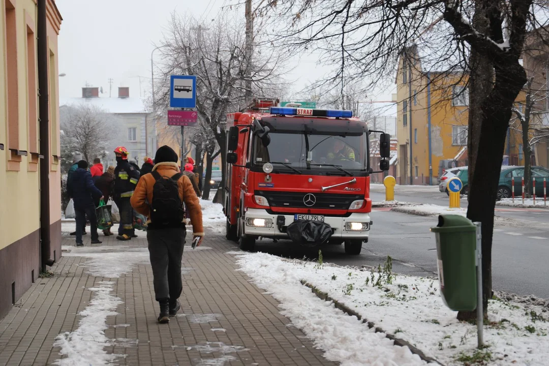 Na przystanku autobusowym w centrum miasta zasłabł starszy mężczyzna, pomagają mu strażacy