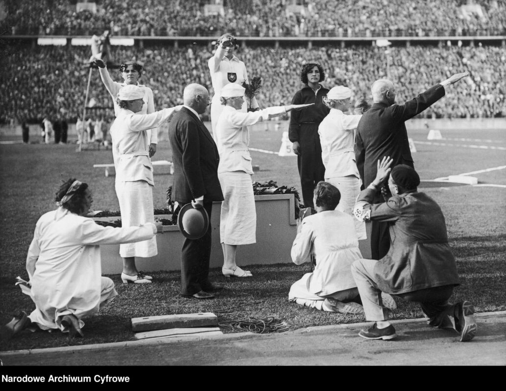 Uroczystość dekoracji medalistek olimpijskiego konkursu w rzucie oszczepem. Maria Kwaśniewska jako jedyna z widocznych na zdjęciu nie wykonuje gestu nazistowskiego pozdrowienia. Berlin, 1936 r., fot. Narodowe Archiwum Cyfrowe