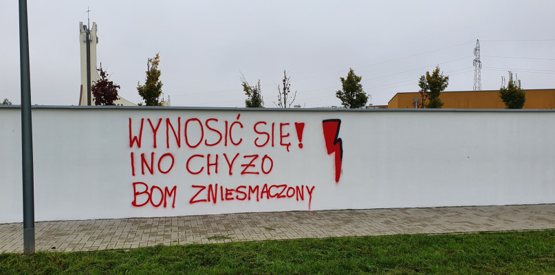 Napis na murze szkoły specjalnej, a obok powstaje mural. - Ręce opadają  - Zdjęcie główne